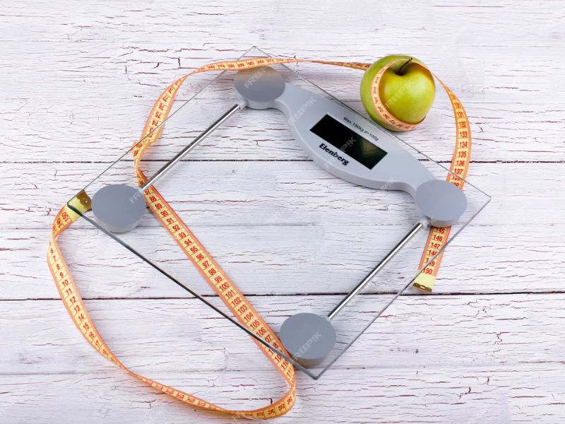 an weighting scale with healthy food aside 
