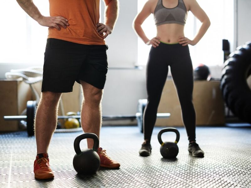 couple doing strength training exercises with kettlebell 