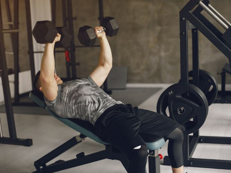 a person doing dumbbell bench press