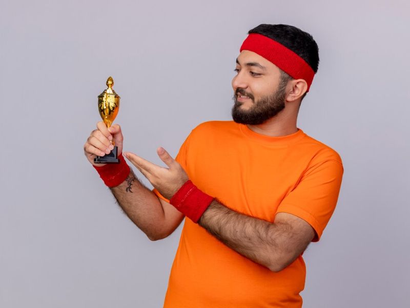 a man lifting trophy for his achievement  