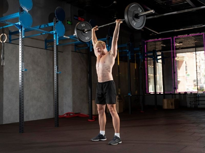 a person doing barbell overhead press