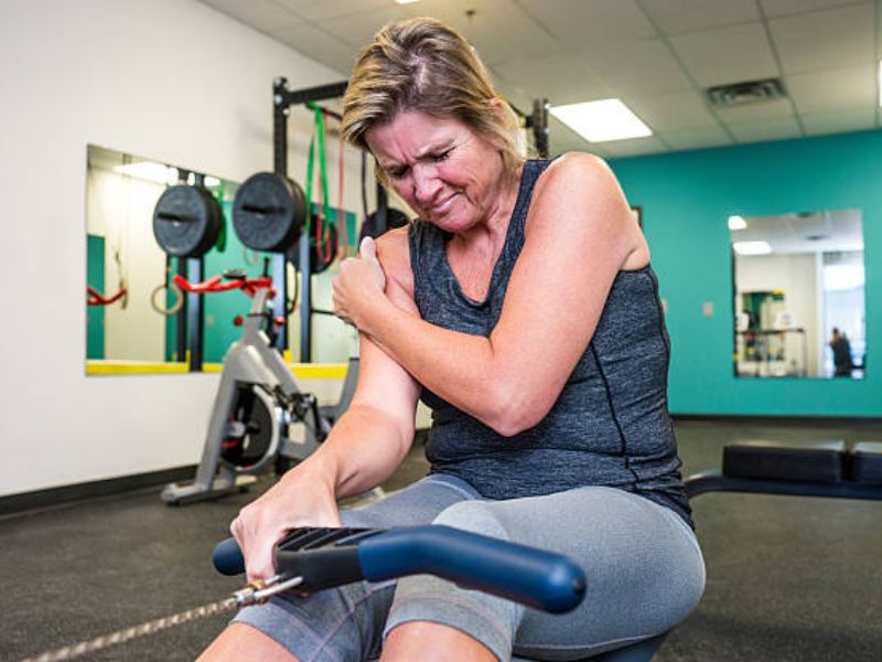 a lady having pain in her body during strength training